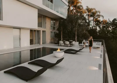 Foyer Serenade 32 en béton avec pare-vent en verre sur une terrasse moderne